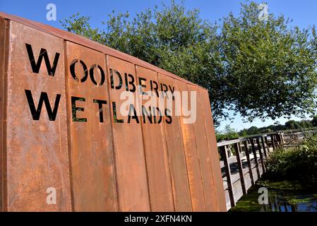 Das Woodberry Wetlands-Schild ist an der Seite des Eingangs aus rostigem Eisen zum urbanen Naturreservat über die Brücke über den New River gestanzt, früher Stoke Newington Reservoir, Hackney, London, England, Großbritannien Stockfoto