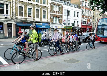 Pendler-Radfahrer in fortgeschrittener Haltespur mit Bus dahinter, London Borough of Islington, England, Großbritannien, Juli 2015. Stockfoto