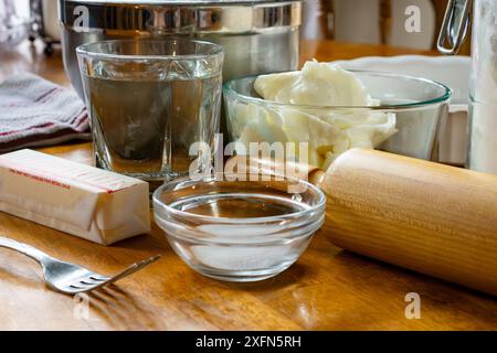 Zutaten für einen Kuchen, einschließlich: Schüssel mit Füllung, Butter, Salz, Wasser, Kürzen, und Mehl für die Kruste. Zu den Utensilien gehören eine Gabel, ein Tortenplatte und Stockfoto
