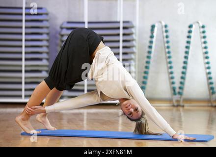 Junge Frau im Fitnessstudio Yoga machen Stockfoto