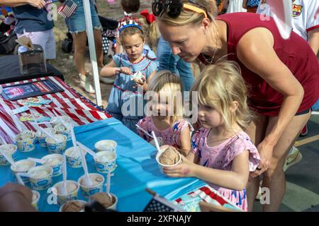 Austin, Tx, USA. Juli 2024. Junge Mädchen schnappen sich Eis während der jährlichen Parade am 4. Juli in Austin, Texas, am 4. Juli 2024. Einige hundert Einwohner gingen zu Fuß auf die 1/2 km lange Parade zur Grundschule und genossen Kekse, Wassermelonen und Eis. (Kreditbild: © Bob Daemmrich/ZUMA Press Wire) NUR REDAKTIONELLE VERWENDUNG! Nicht für kommerzielle ZWECKE! Stockfoto