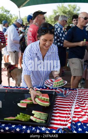 Austin, Tx, USA. Juli 2024. Eine Frau schnappt sich traditionelle Wassermelonen während der jährlichen Parade am 4. Juli 2024 in Austin, Texas. Einige hundert Einwohner gingen zu Fuß auf die 1/2 km lange Parade zur Grundschule und genossen Kekse, Wassermelonen und Eis. (Kreditbild: © Bob Daemmrich/ZUMA Press Wire) NUR REDAKTIONELLE VERWENDUNG! Nicht für kommerzielle ZWECKE! Stockfoto