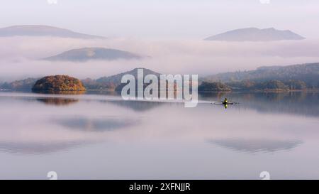 Blick über Derwentwater, in Richtung Friars Crag in Herbstfarbe und Morgennebel mit einsamem Ruderer. In der Nähe von Keswick, Lake District, Cumbria, Großbritannien. November 2016. Stockfoto