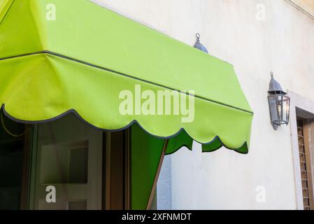 Grüne Markise vor einem Schaufenster. Leerzeichen zum Drucken von Logo oder Text. Perfekt für Ladenwerbung und Branding-Möglichkeiten Stockfoto