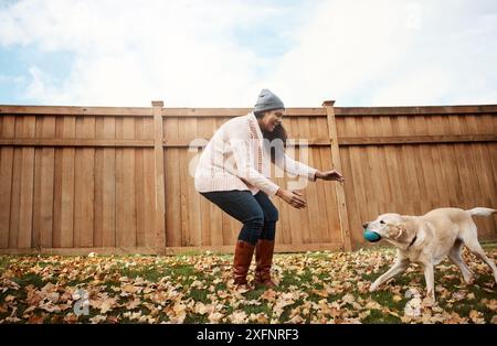 Zuhause, Frau und Spielzeug mit Hund auf dem Hof für Freundschaft, Bindung und Vertrauen mit Sorgfalt und Unterstützung. Weibliche Person, glücklich und Haustierbesitzer mit Spielen für Stockfoto