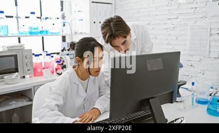 Mann und Frau Wissenschaftlerinnen im Labor zur Analyse von Daten am Computer im Gerät. Stockfoto