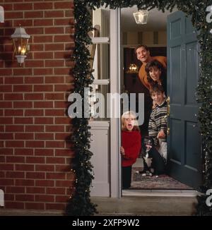 weihnachtszeit mit der Familie. Gäste, Familie, Freunde begrüßen, Geschenke um geschmückten Baum austauschen, Stockfoto
