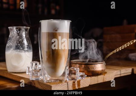 Kaffeegetränk mit Sahne und Eis auf dunklem Holzhintergrund, Kalttonic Drink Kaffee Stockfoto