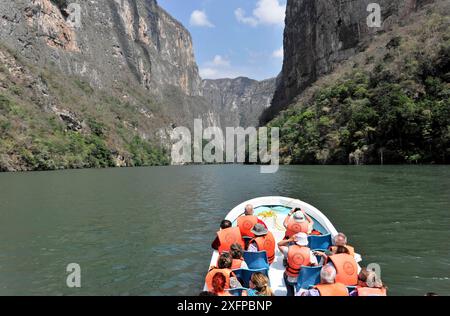 Bootsfahrt durch den beeindruckenden Canyon des Canon del Sunidero, Mexiko, Mittelamerika, Menschen auf einem Boot genießen die Fahrt durch eine malerische Stockfoto