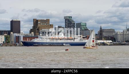 Eine Yacht, die direkt nach dem Beginn des Clipper Round the World Race 2017 an der Hafenpromenade von Liverpool vorbeifährt, wobei das Marco Polo Kreuzfahrtschiff an der Anlegestelle am Pier Head ankert. Merseyside, Großbritannien, August 2017. Stockfoto