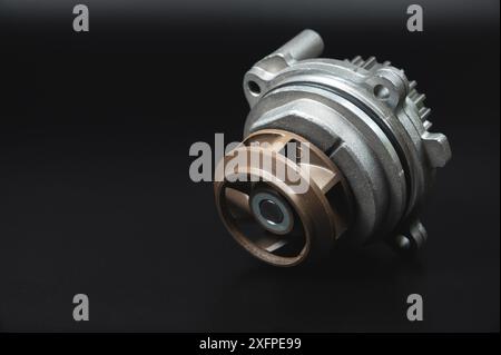 Ersatzteil. Mechanische Wasserpumpe für Motorkühlung. Auf schwarzem Hintergrund Stockfoto