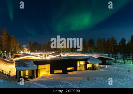 Nordlichter über Hütten im Winter in Kuusamo, Finnland Stockfoto