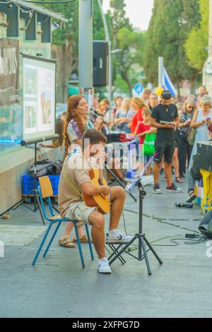 Haifa, Israel - 4. Juli 2024: INBAR Golan und Ofir Kori singen vor der Menge in einer Versammlung zur Unterstützung der Geiselfamilien in Haifa, Israel Stockfoto