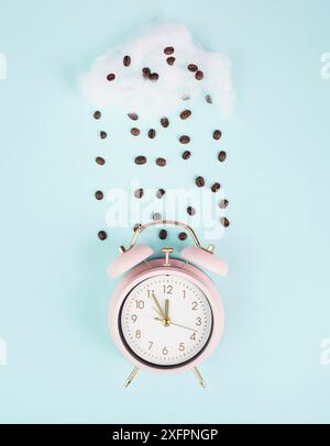 Wachen Sie auf, Zeit für eine Kaffeepause, Wecker mit gerösteten Bohnen, die aus einer Wolke regnen Stockfoto