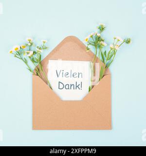 Dankeskarte in einem von Blumen umgebenen Umschlag, Dankbarkeit, Unterstützung, Hilfe und Wohltätigkeitskonzept, positive Einstellung, deutsche Sprache Stockfoto