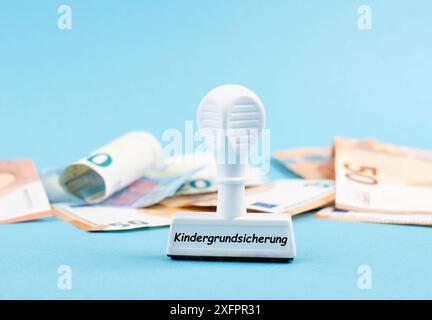 Grundgeld für Kinder steht in deutscher Sprache auf dem Stempel, Euro-Banknoten im Hintergrund, neue Regelung für Familien in Deutschland Stockfoto