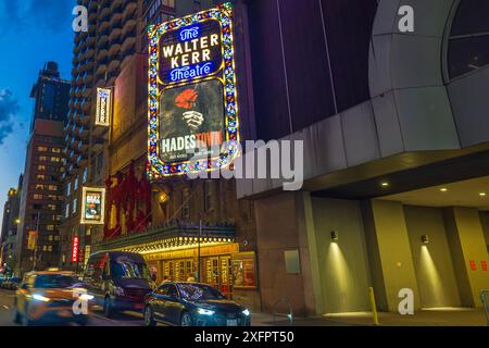 Wunderschöner Blick auf das Walter Kerr Theatre in New York City in der Abenddämmerung mit einem lebhaften Festzelt für das Musical „Hadestown“, mit Autos, die auf der Straße vorbeifahren Stockfoto