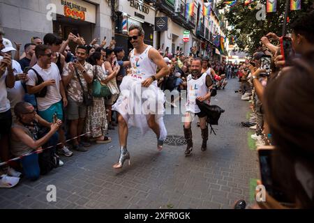 Madrid, Spanien. Juli 2024. Die Teilnehmer laufen während des Heel Race in der Pelayo Street mit High Heels. Im LGTBIQ-Viertel Chueca fand die 25. Auflage des Heel Race statt, ein sportlich-festlicher Test, bei dem die Teilnehmer mit bis zu 15 Zentimeter hohen Heels laufen müssen. Quelle: SOPA Images Limited/Alamy Live News Stockfoto