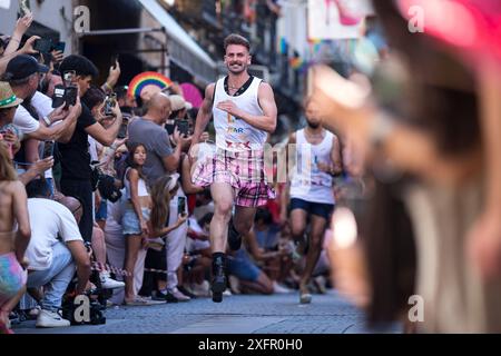 Madrid, Spanien. Juli 2024. Die Teilnehmer laufen während des Heel Race in der Pelayo Street mit High Heels. Im LGTBIQ-Viertel Chueca fand die 25. Auflage des Heel Race statt, ein sportlich-festlicher Test, bei dem die Teilnehmer mit bis zu 15 Zentimeter hohen Heels laufen müssen. Quelle: SOPA Images Limited/Alamy Live News Stockfoto