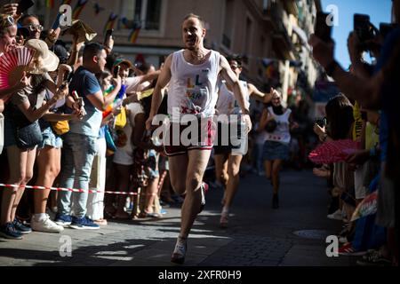 Madrid, Spanien. Juli 2024. Die Teilnehmer laufen während des Heel Race in der Pelayo Street mit High Heels. Im LGTBIQ-Viertel Chueca fand die 25. Auflage des Heel Race statt, ein sportlich-festlicher Test, bei dem die Teilnehmer mit bis zu 15 Zentimeter hohen Heels laufen müssen. Quelle: SOPA Images Limited/Alamy Live News Stockfoto