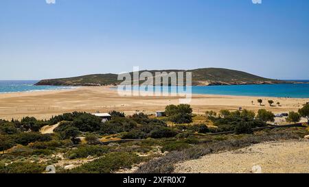 Ein ruhiger Strand mit Sanddünen und einer üppig grünen Insel im Hintergrund unter einem hellblauen Himmel, Prasonisi, Insel im Süden von Rhodos, Rhodos Stockfoto