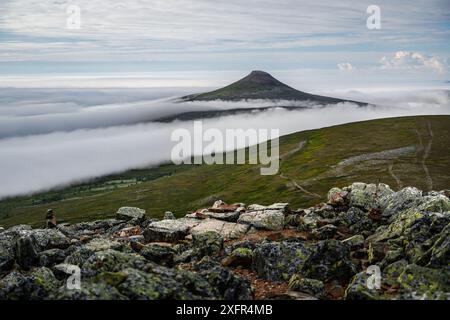 Der Städjan-Gipfel erhebt sich über einem Nebelmeer in Idre Dalarna, Schweden. Der Nebel rollt über die Hügel und das Tal und schafft eine malerische Landschaft Stockfoto