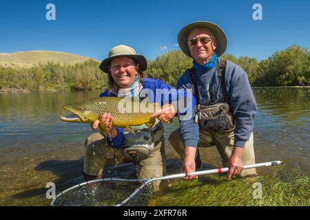 Mann und Frau mit dem Preis 6 kg männliche Hakenforelle (Salmo trutta) Beaverhead River, Montana, USA. Stockfoto