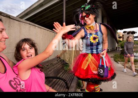 Der Park Ranger Niki Lake gibt sich als „Batty the Clown“ aus und bringt dem Kind den „Fledermaus Handshake“ bei, in San Antonio, wo eine Junggesellenkolonie mexikanischer Freischwanzfledermäuse (Tadarida brasiliensis) unter der Brücke lebt. San Antonio, Texas, USA, Juli 2015. Stockfoto