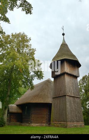 Alte hölzerne Kirche und Glockenturm mit Strohdächern aus Masuren, nun innerhalb der ethnographische Park, Olsztynek, Polen, September 2017. Stockfoto