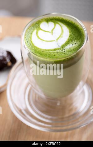 Warmer und beruhigender heißer Matcha Latte: Eine reichhaltige Mischung aus hochwertigem Matcha-Grüntee und aufgeschäumter Milch, die eine cremige Textur und einen erdigen Geschmack bietet. Stockfoto