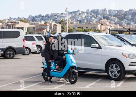 Junges asiatisches Touristenpaar auf einem Roller, das eine gute Zeit genießt Stockfoto