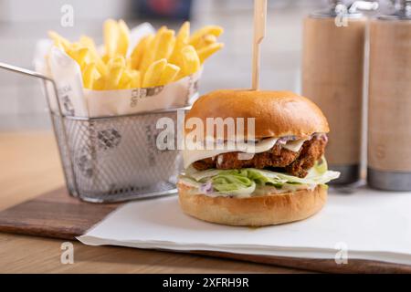 Köstlicher hausgemachter Hühnchenburger. Ein saftiges und aromatisches gegrilltes Hähnchenpastete, perfekt gewürzt, eingebettet in ein weiches, geröstetes Brötchen. Stockfoto