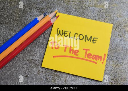 Konzept „Willkommen beim Team“ Schreiben Sie auf Haftnotizen, die auf Holztisch isoliert sind. Stockfoto