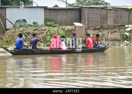 Morigaon, Assam, Indien. Juli 2024. MORIGAON, ASSAM, INDIEN-04. JULI 2024: Dorfbewohner reisen auf einem Boot durch ein überflutetes Dorf im Morigaon District in Assam. (Kreditbild: © Hafiz Ahmed/ZUMA Press Wire) NUR REDAKTIONELLE VERWENDUNG! Nicht für kommerzielle ZWECKE! Stockfoto