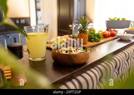 Frischer Salat und Limonade auf der Küchenzeile mit Obst und Gemüse Stockfoto