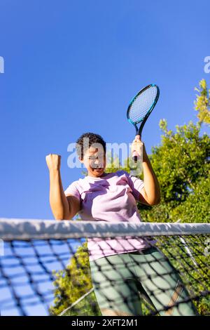 Tennisschläger halten, Frau feiert den Sieg auf dem Platz im Freien Stockfoto