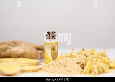 Natürliches Ingweröl in Glasflasche unter Ingwerwurzeln Stockfoto