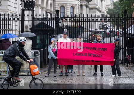 London, Großbritannien. Juli 2024. Aktivisten von Green New Deal Rising demonstrieren am Morgen des Wahlergebnisses vor den Toren der Downing Street, mit einer Botschaft auf einem Banner an die neue Labour-Regierung von jungen Leuten, die besagt: "Tory Albtraum over, Labour be BOLD". Quelle: David Mirzoeff/Alamy Live News Stockfoto