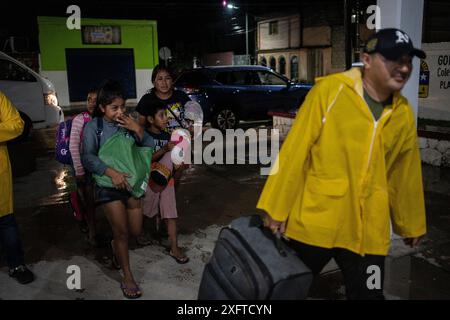 Tulum, Mexiko. Juli 2024. Eine Familie geht in eine Notunterkunft, um sich vor den Folgen des herannahenden Hurrikans „Berly“ zu schützen. Quelle: Felix Marquez//dpa/Alamy Live News Stockfoto