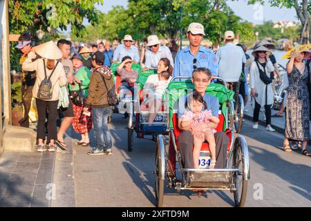 Hoi an (Hoian), Vietnam - 11. April 2018: Asiatische Touristen reiten Trischas (Radrikschas) in der antiken Stadt Hoi an. Stockfoto