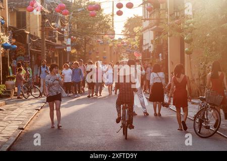 Hoi an (Hoian), Vietnam - 11. April 2018: Touristen gehen bei Sonnenuntergang entlang der Fußgängerzone der antiken Stadt. Stockfoto