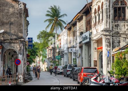 Penang Island, Malaysia - 25. April 2023: Die Menschen schlendern durch die engen Straßen der Altstadt, am späten Nachmittag, inmitten der verblassten und charaktervollen Stockfoto