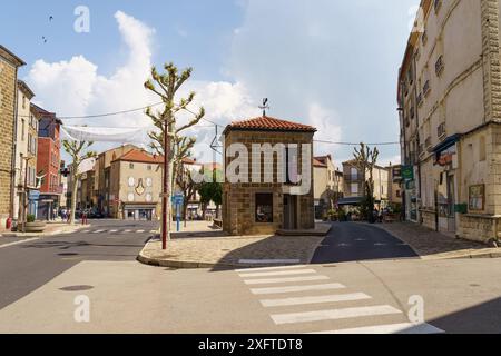 Langeac, Frankreich - 28. Mai 2023: Ein kleiner Steinturm steht in der Mitte eines französischen Marktplatzes mit Kopfsteinpflasterstraßen und charmanten Gebäuden Stockfoto