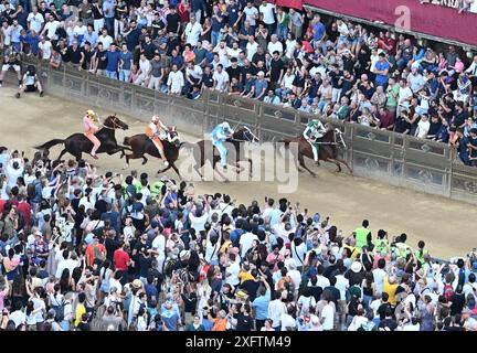 Siena, Italien. Juli 2024. Die Teilnehmer nehmen am Pferderennen auf dem Palio in Siena, Italien, am 4. Juli 2024 Teil. Palio in Siena, italienisch „Palio di Siena“, ist ein historisches Pferderennen, das seit 1656 zweimal jährlich in Siena stattfindet. Quelle: Elisa Lingria/Xinhua/Alamy Live News Stockfoto