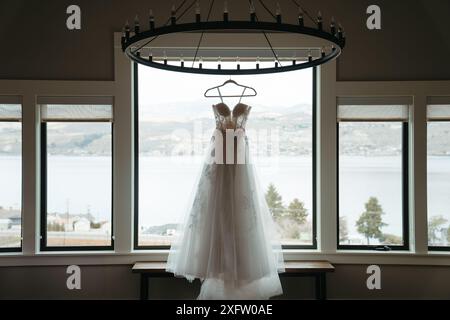 Elegantes Hochzeitskleid, das an einem Kronleuchter hängt Stockfoto