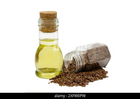 Rohe Leinsamen in einem transparenten Behälter und Leinöl in einer Glasflasche auf weißem Hintergrund. Stockfoto
