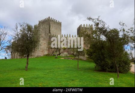 18.02.2014 Guimarães, Portugal - die Burg von Guimarães scheint unter der hellen Sonne unter blauem Himmel und üppigem Grün Stockfoto