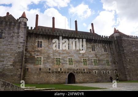 18.02.2014 Guimarães, Portugal - die Burg von Guimarães scheint unter der hellen Sonne unter blauem Himmel und üppigem Grün Stockfoto