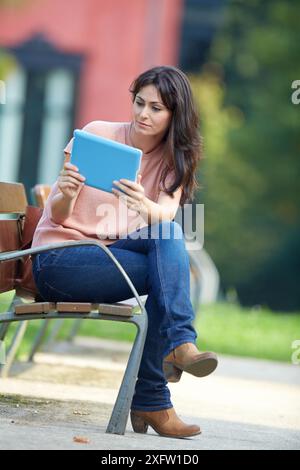 35 Jahre alte Frau mit Tablet-PC in einem Park. Donostia. San Sebastian. Gipuzkoa. Baskisches Land, Spanien. Stockfoto