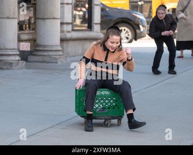 Während der Pause in einer jüdischen Pfarrschule rollt ein Junge auf einem improvisierten Spielzeug herum. In Brooklyn, New York. Stockfoto